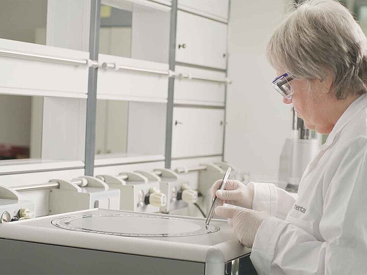 Female lab employee is placing samples on an elemental analyzer